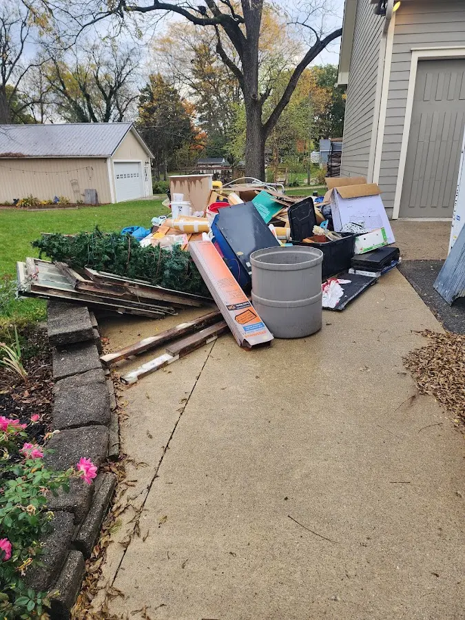 Dumpster being loaded with debris for Estate Cleanout Dumpster Rental in L'Anse